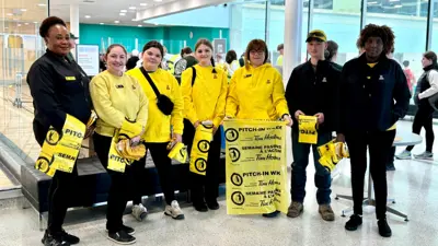 A group of volunteers at the MacBain Community Centre in Niagara Falls. The group is holding yellow trash bags, ready to begin the Community Clean Up event.