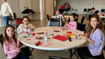 Youth sitting at a round table doing crafts.
