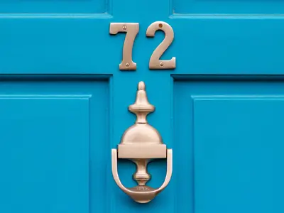 Blue door with number 72 and a door knocker.