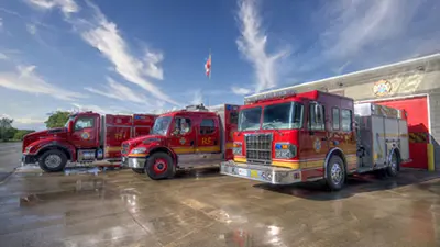 Three firetrucks parked in front of a Niagara Falls Fire Station.