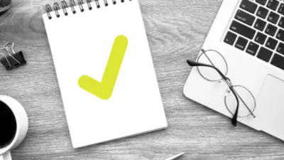 A pad of paper with a green checkmark beside a calculator