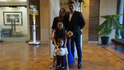 Family standing in front of wedding backdrop on second floor of City Hall