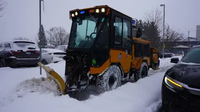Snowplow clearing city sidewalk 