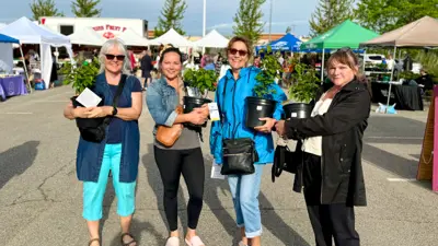 Four women holding trees at the Free Tree Giveaway at the MacBain Community Centre.