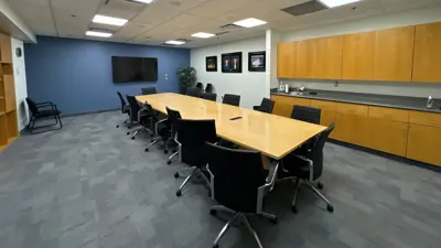 MacBain Community Centre board room with large table, chairs, counter and tv screen.