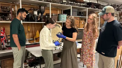 Image of Museum staff in the stock area examining artifacts.