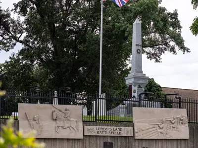 Commemorative wall featuring four limestone panels depicting scenes from the battle of Lundy's Lane.
