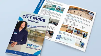 Decorative graphic of the new 2025 City Guide showing the front cover and a flipped open page of the inside with City Guide wordmark 