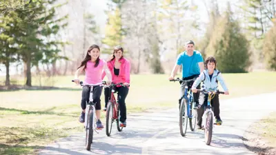 Family riding bicycles along path