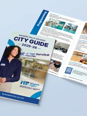 The City of Niagara Falls 2025 City Guide showing a closed guide with the cover, and an open guide above showcasing the pages.