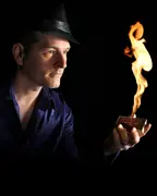 Greg Frewin holding a deck of cards on fire.