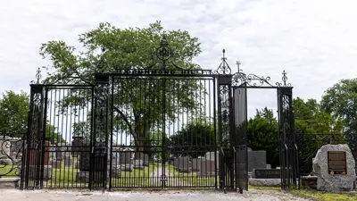 Drummond Hill Cemetery in Niagara Falls at the front gate. The gates are black iron with decorative iron scrolls.