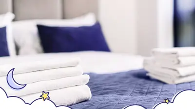 Graphic of a bed with towels placed on it, clouds, moon and stars